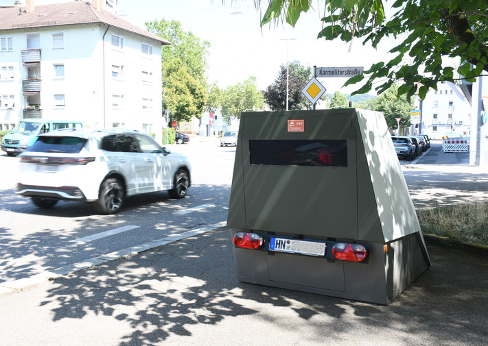 Das Bild zeigt einen mobilen Blitzeranhänger, den die Stadt Heilbronn zur Tempoüberwachung am Straßenrand einsetzt. 