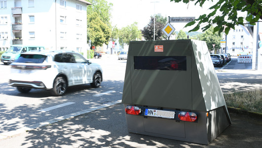Das Bild zeigt einen mobilen Blitzeranhänger, den die Stadt Heilbronn zur Tempoüberwachung am Straßenrand einsetzt. 
