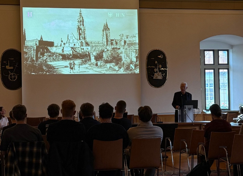 Auszubildende und Studierende sitzen im Großen Ratssaal und verfolgen eine Präsentation zur Stadt Heilbronn.