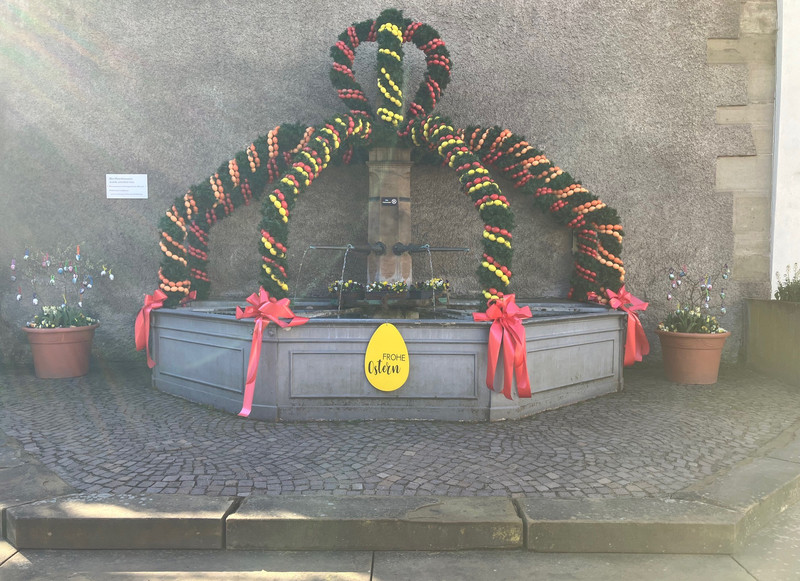 Das Bild zeigt den geschmückten Vierröhrenbrunnen im Ortskern von Biberach.