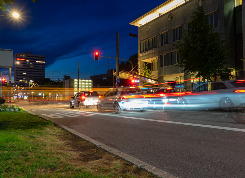 Das Bild zeigt fahrende Autos in der Abenddämmerung an der Allee in Heilbronn. 
