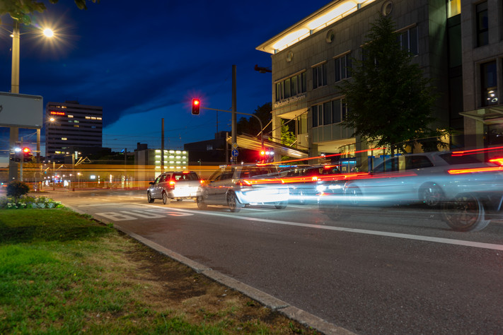 Das Bild zeigt fahrende Autos in der Abenddämmerung an der Allee in Heilbronn. 