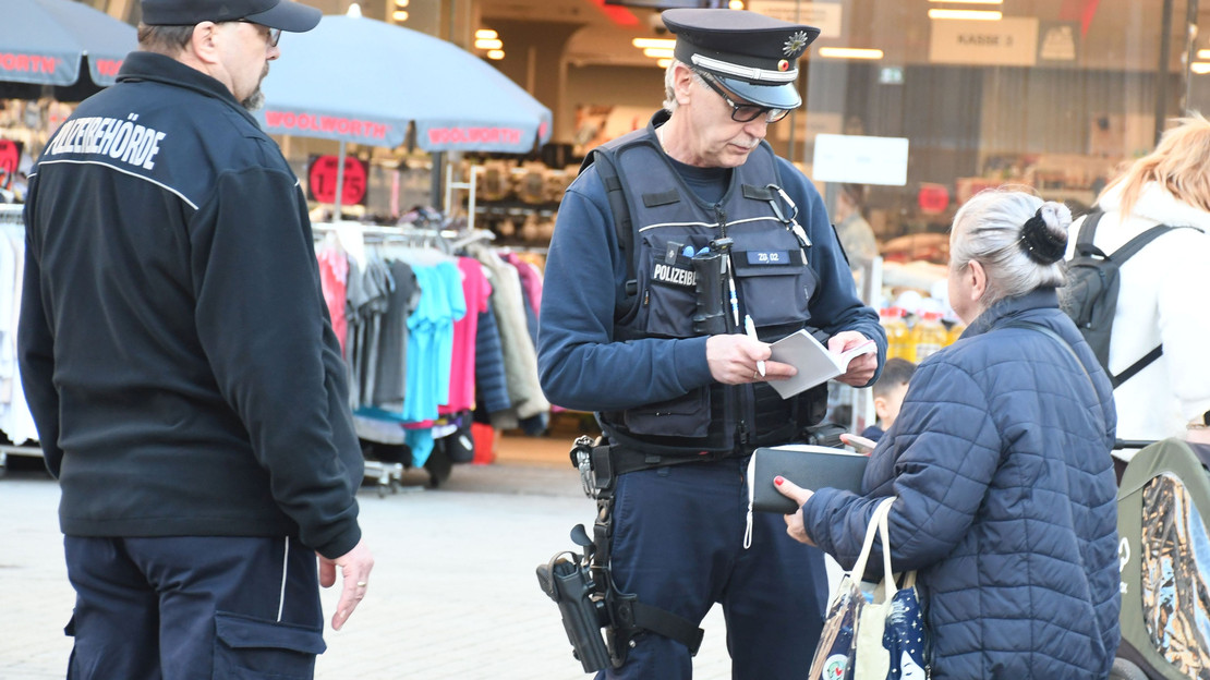 Das Bild zeigt zwei Mitarbeiter des Kommunalen Ordnungsdientes bei einer Kontrolle am Kiliansplatz. Eine Frau hatte achtlos eine gerauchte Zigarette weggeworfen. 