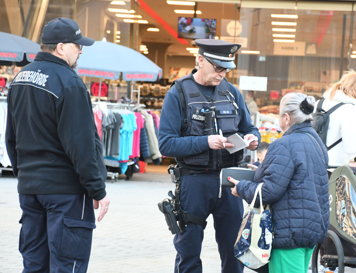 Das Bild zeigt zwei Mitarbeiter des Kommunalen Ordnungsdientes bei einer Kontrolle am Kiliansplatz. Eine Frau hatte achtlos eine gerauchte Zigarette weggeworfen.
