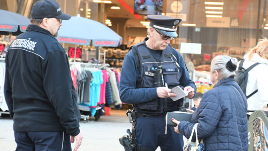 Das Bild zeigt zwei Mitarbeiter des Kommunalen Ordnungsdientes bei einer Kontrolle am Kiliansplatz. Eine Frau hatte achtlos eine gerauchte Zigarette weggeworfen. 