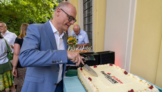 Geschäftsführer Steffen Schoch schneidet Kuchen an