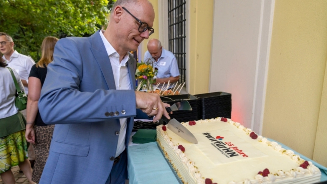Geschäftsführer Steffen Schoch schneidet Kuchen an