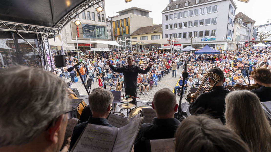 Das Bild zeigt einen Chor mit Orchester auf der Bühne am gut gefüllten Kiliansplatz bei Magie der Stimmen. 