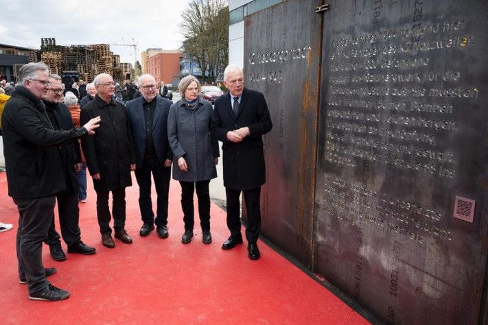 Das Bild zeigt Oberbürgermeister Harry Mergel, Archivleiterin Miriam Eberlein, Bernhard Löffler und Heinz Risel, beide von der Gedenkstätten-Initiative, Bürgermeister Andreas Ringle und Grünflächenamtsleiter Oliver Toellner an einer der Stahlwände am neuen Gedenkort 