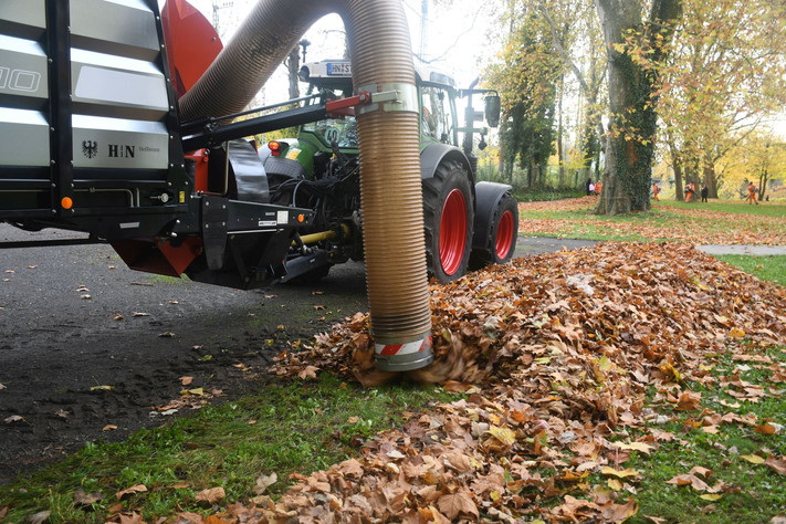 Das Bild zeigt den Saugrüssel des sogenannten Laubelefanten. Mit viel Druck saugt das Gerät die Laubhügel zum Abtransport in einen Anhänger.
