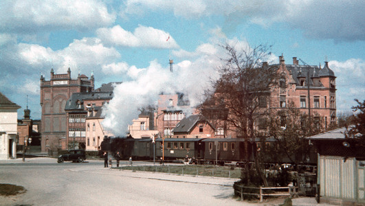 Das Bild zeigt eine Dampflok, die um das Jahr 1940 vom Südbahnhof mit Personenwaggons Richtung Sontheim fährt. Im Hintergrund sind Werksgebäude der Firma Knorr zu sehen. Das Gebäude rechts wurde 1898 erbaut. In den 1930er Jahren war dort die Gaststätte "Fleinerhöhe". 