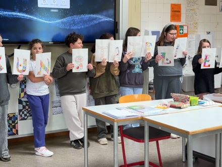 Schülerinnen und Schüler der Dammrealschule präsentieren im Klassenraum ihre Kunstwerke mit dem Schriftzug Kunstatelier.