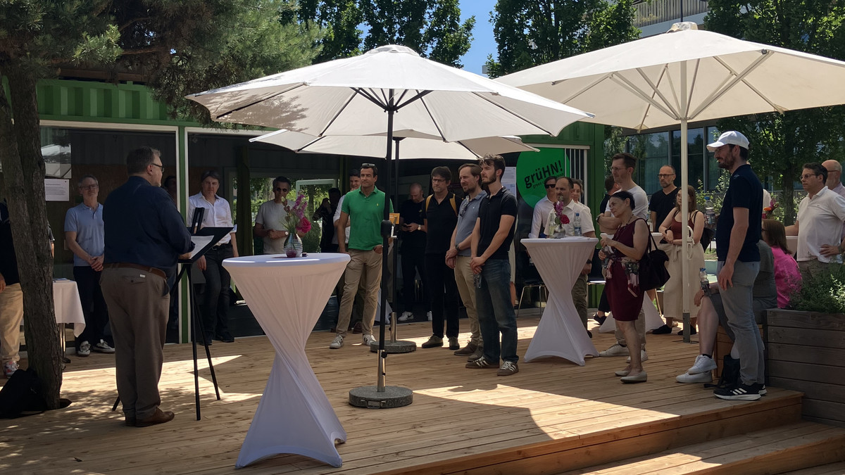 Gäste verfolgen das Grußwort von Bürgermeister Ringle bei der Langen Tafel der Baukultur im Stadtquartier Neckarbogen.