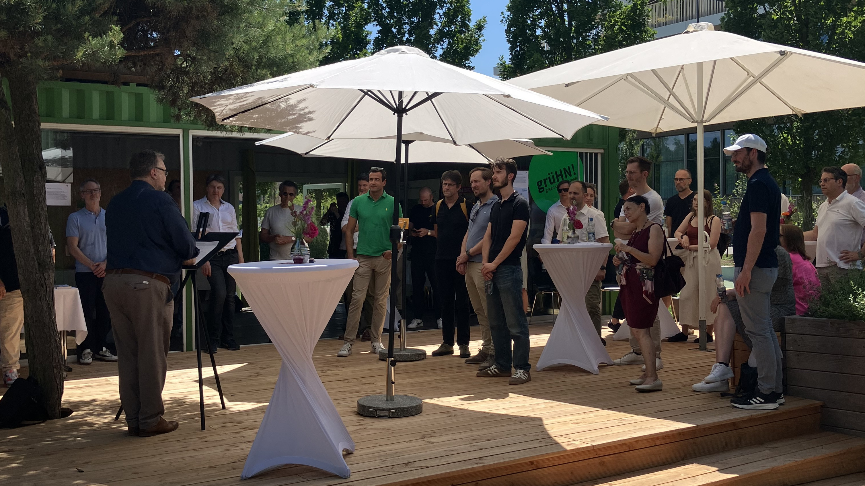 Gäste verfolgen das Grußwort von Bürgermeister Ringle bei der Langen Tafel der Baukultur im Stadtquartier Neckarbogen.