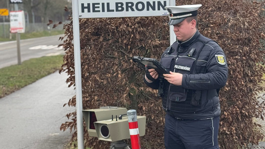 Auf dem Bild ist ein Mitarbeiter der Stadt mit einem mobilen Tempo-Messgerät am Straßenrand zu sehen. 