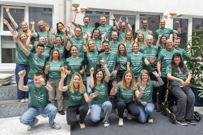 Auf dem Foto sind einige Mitarbeitende der Stadt Heilbronn zu sehen, die sich über ihre neuen Laufshirts für den Trollinger Marathon freuen. 