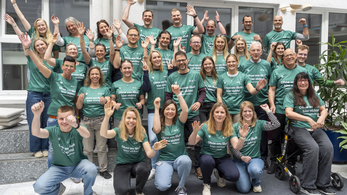 Auf dem Foto sind einige Mitarbeitende der Stadt Heilbronn zu sehen, die sich über ihre neuen Laufshirts für den Trollinger Marathon freuen. 