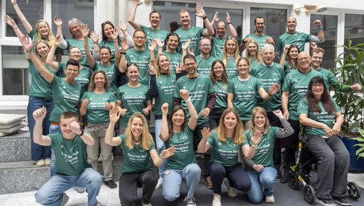 Auf dem Foto sind einige Mitarbeitende der Stadt Heilbronn zu sehen, die sich über ihre neuen Laufshirts für den Trollinger Marathon freuen. 