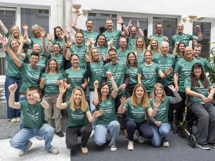 Auf dem Foto sind einige Mitarbeitende der Stadt Heilbronn zu sehen, die sich über ihre neuen Laufshirts für den Trollinger Marathon freuen. 