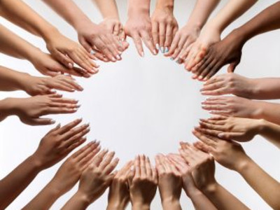 Man sieht viele Hände, die einen Kreis bilden.