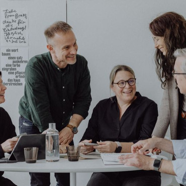 Man sieht fünf Personen an einem Besprechungstisch - hier klicken für den Bereich "Impressionen" 