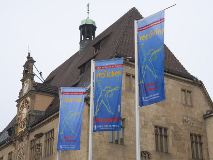 Das Bild zeigt wehende Fahnen zum Internationalen Aktionstag gegen Gewalt an Frauen. Sie wehen vor dem Heilbronner Rathaus. 