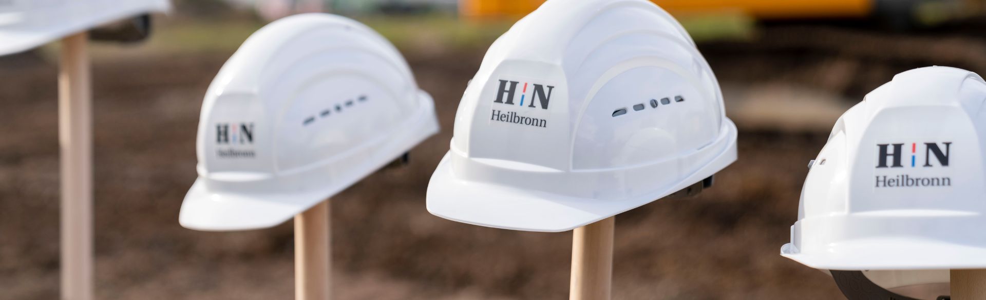 Man sieht Baumhelme, die auf einer Schaufel hängen