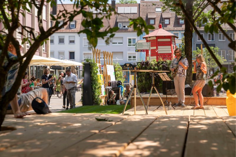 Eine Frau und ein Mann machen Musik auf dem Holzpodest