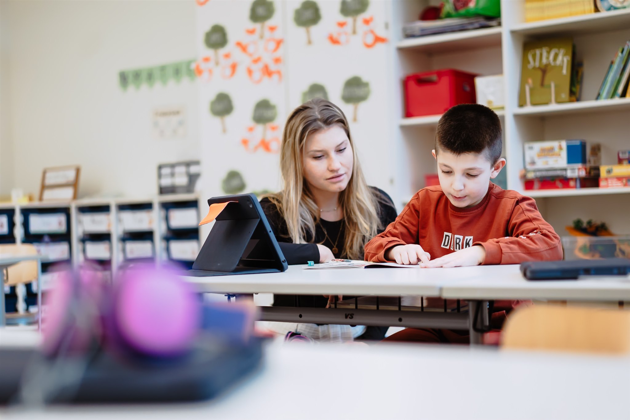 Man sieht eine Lehrerin und einen Schüler beim Erledigen einer Aufgabe. Foto: Akademie für Innovative Bildung und Management