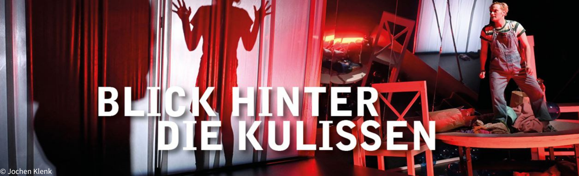 Bühnenszene in rotem Licht mit einer Person auf der Bühne und einer silhouettierten Figur hinter einem Vorhang. Im Vordergrund steht der Schriftzug „Blick hinter die Kulissen“, der einen Einblick in die Theaterarbeit ankündigt.