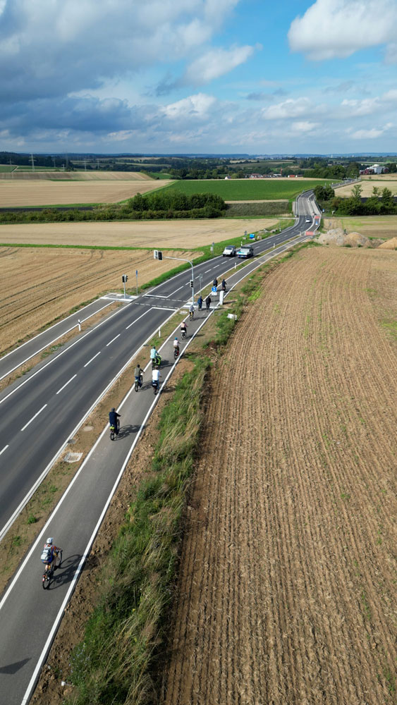 Drohnenaufnahme des neuen Radwegs während der Befahrung durch die Gruppe.