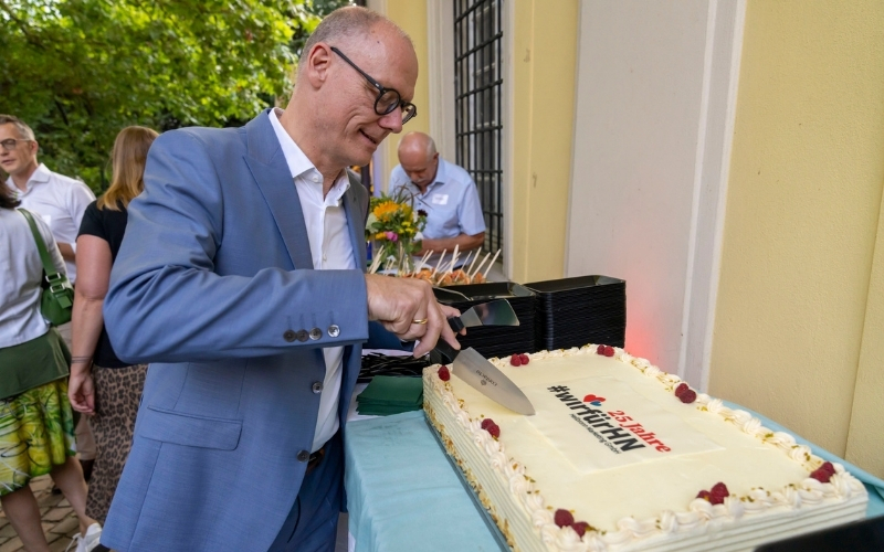 Mann schneidet Kuchen an