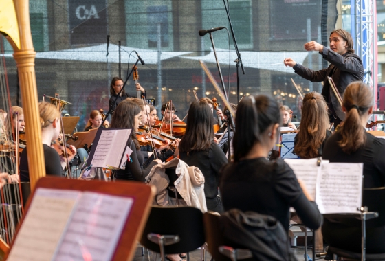 Ein Orchester steht auf der Bühne und spielt